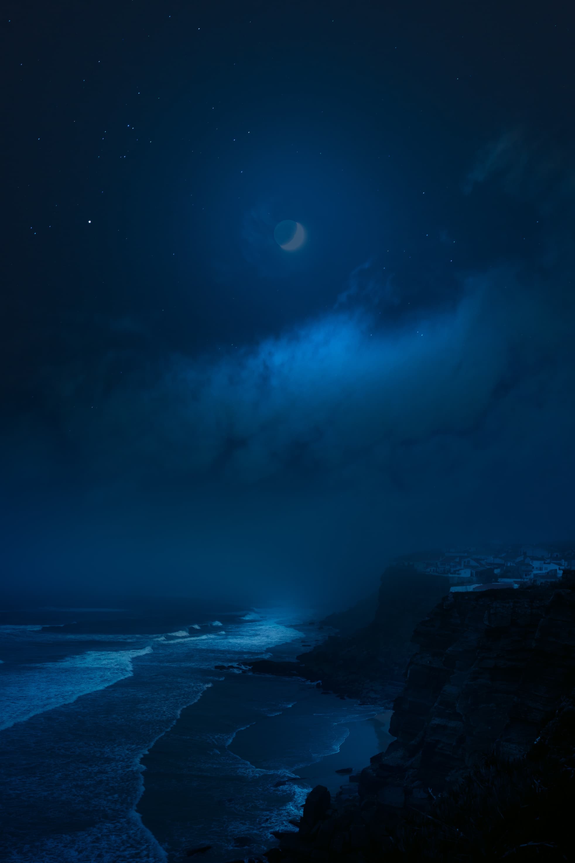 Ocean at night with a dim moon in the background